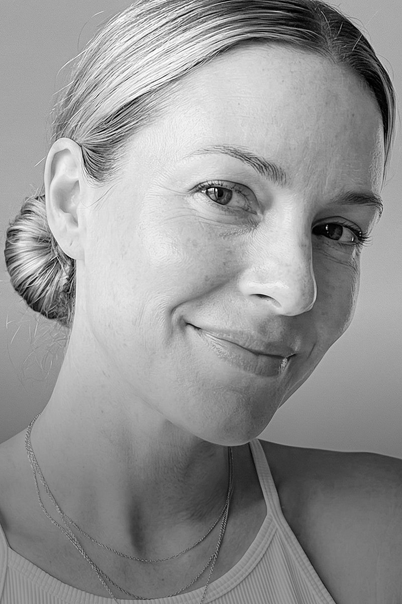 Black and white portrait of a smiling woman.