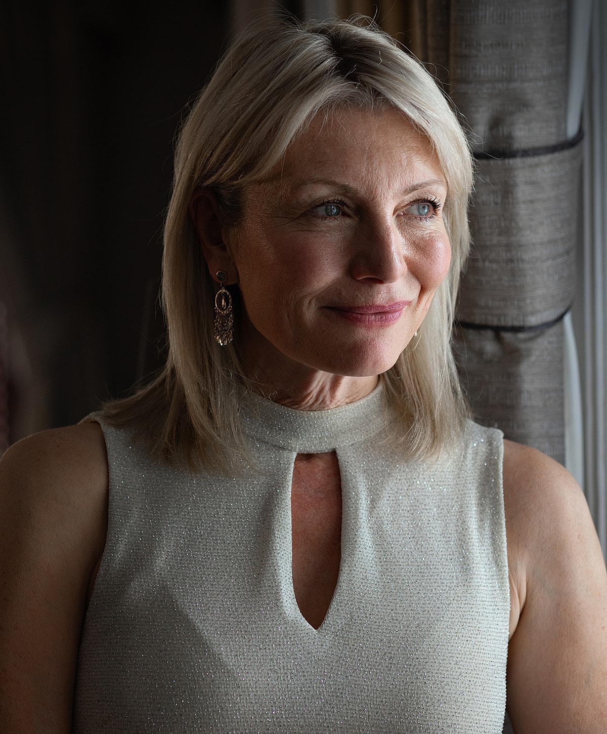 Woman with blonde hair in elegant attire.