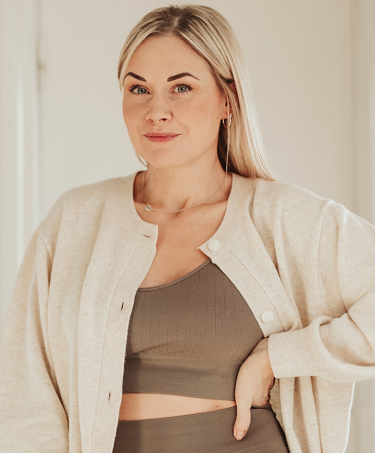 Woman posing in cozy, layered fashion outfit.