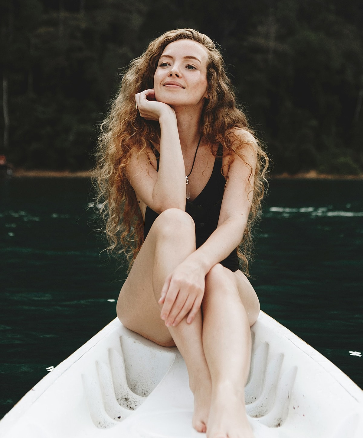 Woman relaxing on a canoe by the water.