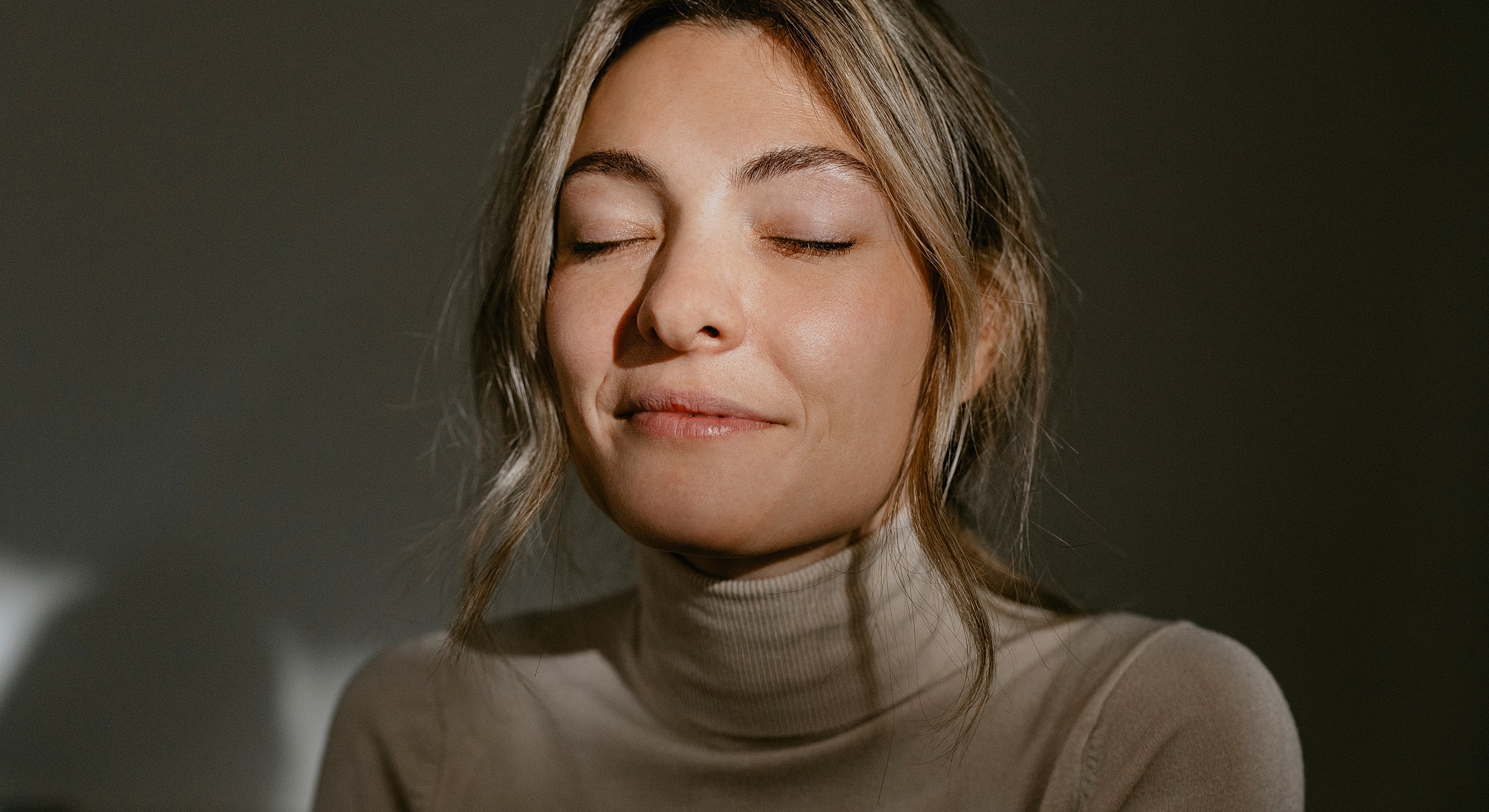 Woman with closed eyes and soft smile.