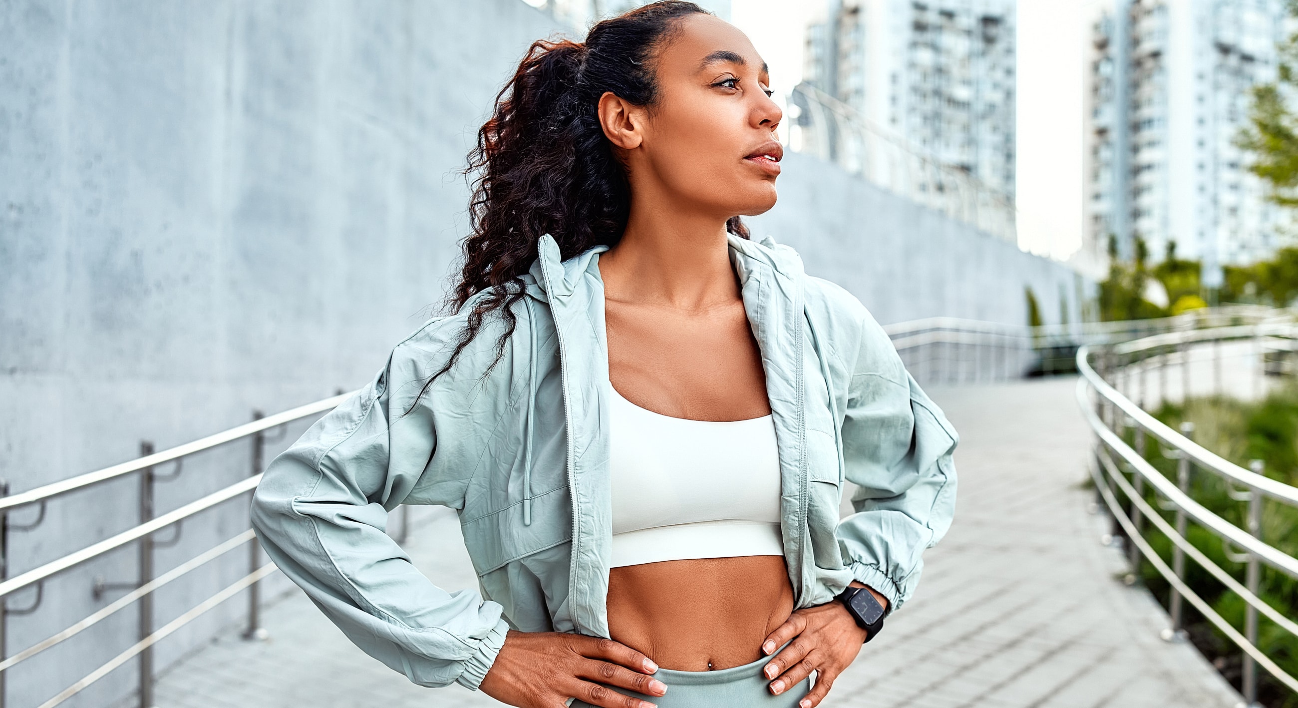 Woman in athletic wear outdoors, confidently posing.